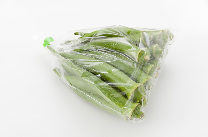 新鲜秋葵在塑料袋孤立白色背景。