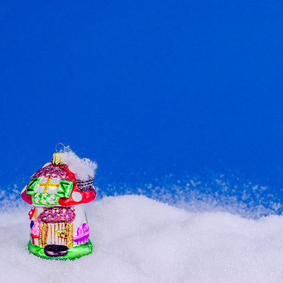 彩色的圣诞房子在雪在蓝色的背景。圣诞节和新年的概念。圣诞贺卡。