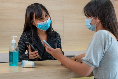 前台接待员和客人戴口罩。