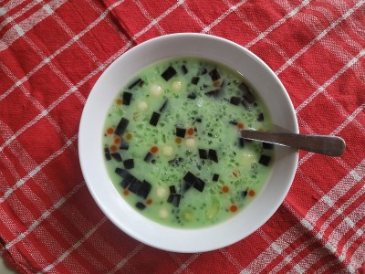 Es Campur。冰东南甜点，水果，果冻泡沫，面条果冻，罗勒籽在甜的绿色糖浆和牛奶汤在红色的毛巾背