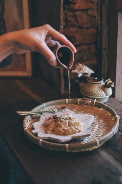 手工将红糖糖浆倒入Warabi-mochi或Kinako mochi，在复古背景下的蕨淀粉饺子。日本