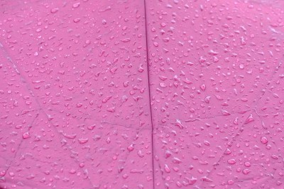 特写许多雨滴在紫色伞表面为背景纹理