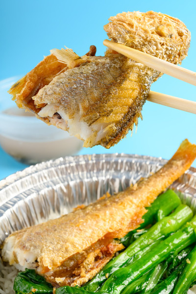 筷子从一碗快餐中夹出小黄鱼或小黄鱼
