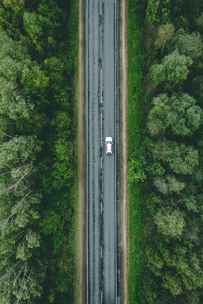 鸟瞰图的乡村道路与汽车通过绿色的森林和玉米田