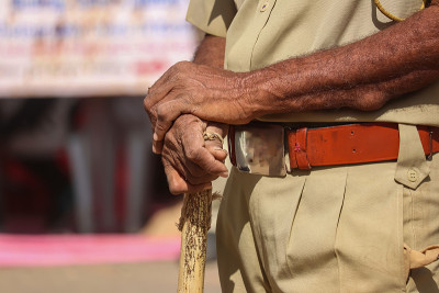 印度警察靠近警棍和制服，印度警察(CRPF)用竹棍巡逻，选择性聚焦，警察手牵手查看