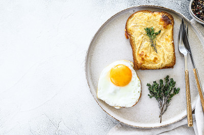 Croque Monsieur是一款传统法式烤奶酪火腿三明治，配白汁。白色背景。前视图。本空间