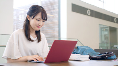 年轻的亚洲女学生使用笔记本电脑。