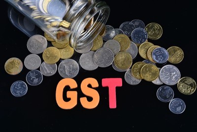 硬币从钱罐里洒出来，上面写着GST