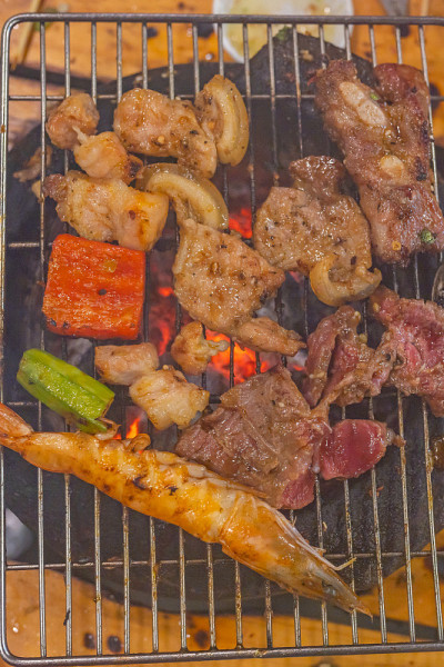 肉和虾在木炭烤炉上的垂直照片