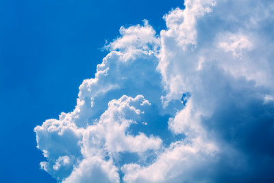 蓝天上卷曲的白云。天空背景