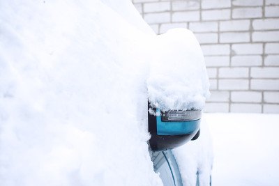 冬季汽车进入紧急状态。与天气有关的紧急情况。在冬天的暴风雪中，汽车被雪覆盖了。车前的后视镜被冰雪覆盖