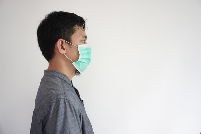 亚洲男子戴口罩预防Covid - 19或冠状病毒