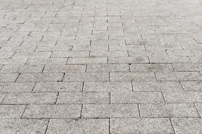街道道路地面上单调的灰色砖石的透视图。人行道，车道，铺路机，路面在复古设计地板广场图案纹理背景