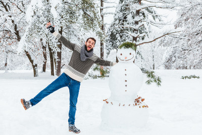 一个年轻人在公园里堆雪人