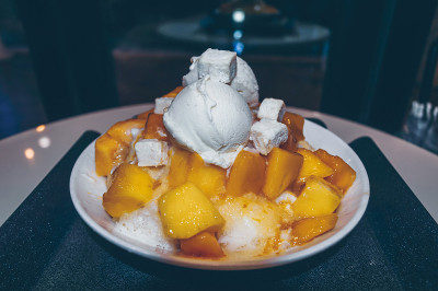 近距离观看新鲜制作的碗芒果bingsoo -韩式刨冰甜点与甜配料