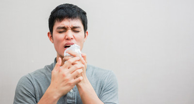 对过敏或感染流感病毒后打喷嚏的亚洲年轻人采取封闭措施，起床后在家用纸巾擦鼻子，这是不健康的生活方式理