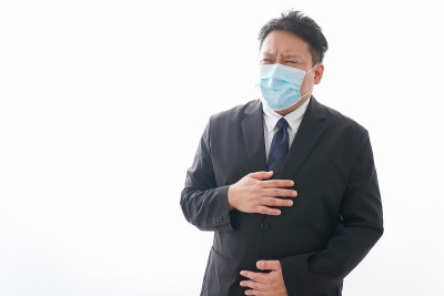 男人忍受着腹痛，戴着面具
