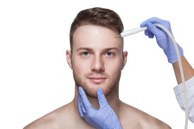 男性的美容。美容师给一个男人做去除脸上痤疮的手术。