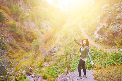 女性徒步旅行者在山林中自拍。