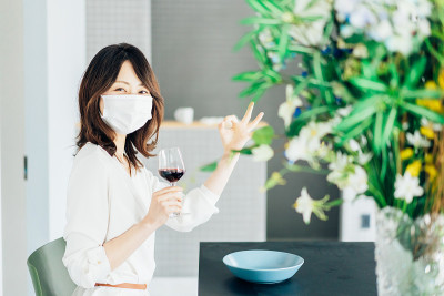 年轻女子戴着面具喝酒