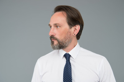 面部护理。成熟的商人有灰白的头发。自信而英俊的男人。男性正式的时装。成功的高级商人穿衬衫打领带。办公