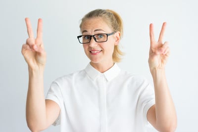 戴眼镜的学生微笑着表示胜利