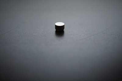 一个按钮电池助听器在棕色的木桌上。