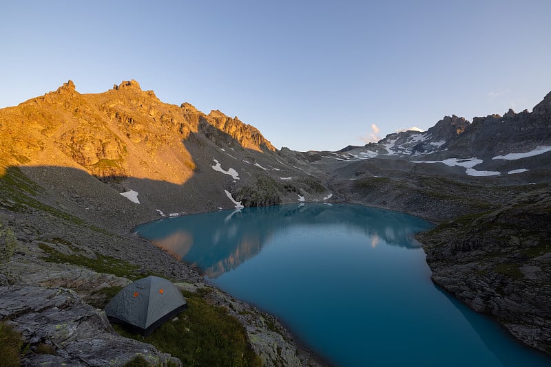 圣加仑州一个叫做Wildsee的高山湖泊的美丽景色。瑞士阿尔卑斯山壮丽的日落。帐篷在前面，景色很美，