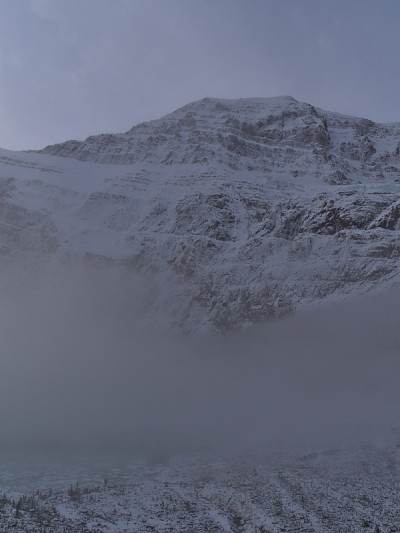 雄伟的伊迪丝卡维尔山与白雪覆盖的岩石在碧玉国家公园，加拿大阿尔伯塔，在落基山脉上方秋天的浓雾。