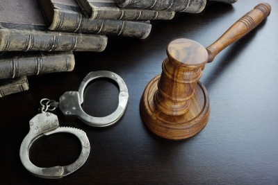 法官的木槌，手铐和黑桌上的旧书