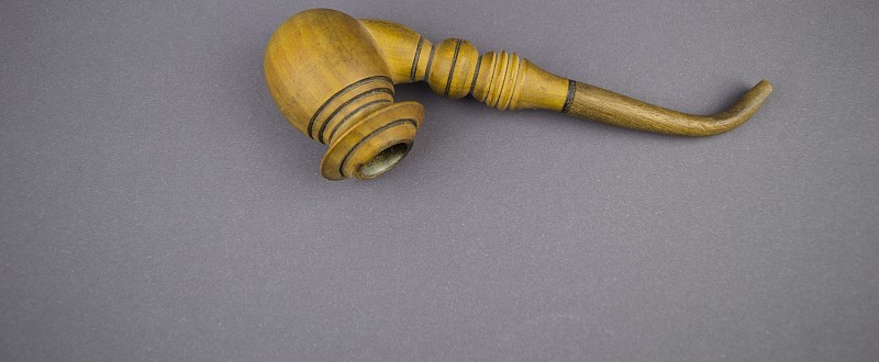灰色背景上的木制烟斗，需要填补空白