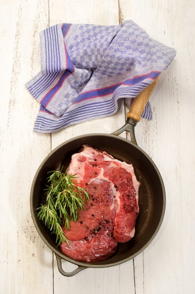 生牛肩肉与迷迭香在平底锅中