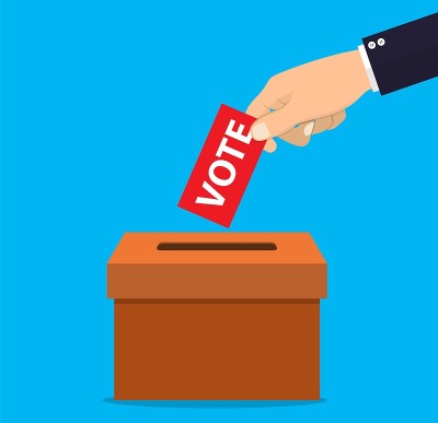 Human hand putting voting pape