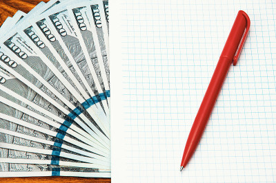 Close-up of US dollars spread out, an empty busine