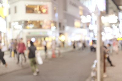 在日本拥挤的街道上，人们走在夜晚的人行道上，模糊的背景用于背景使用。