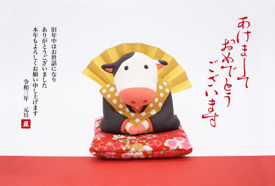 一张由日本传统人物福岛(Fukusuke)装扮的牛雕塑制作的新年卡片。这个雕塑是用粘土做的。