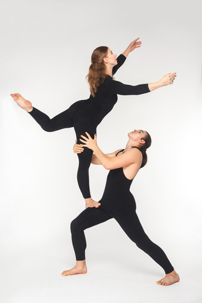 年轻的夫妇在做acroyoga体式练习平衡。