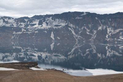 在冰岛的阿斯加火山口的高地上Öskjuvatn的水里的山脉的倒影。