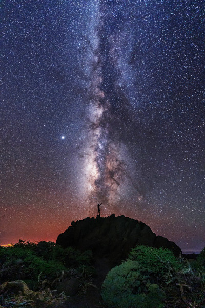 在加那利群岛的拉帕尔马岛，一个年轻人的剪影在星星下看着塔布里恩特火山口附近的lactea方式。西班牙