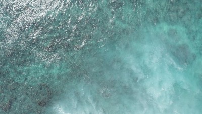 在黄金时刻飞过海洋。巨大的波浪在海洋中激起泡沫和水花。冲浪者乘风破浪。夏威夷瓦胡岛上的太平洋海水的蓝