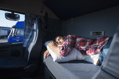 卡车司机在他的卡车里睡觉。睡眠不足。疲劳。