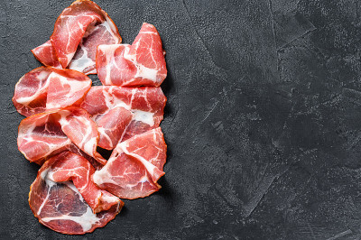 意大利熏肉卷。猪肉。黑色背景。前视图。本空间