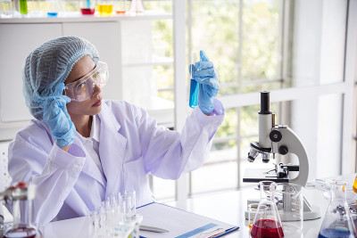 特写女科学家手用滴管在实验室看科学显微镜医学试验，研究生物化学。女性技术员实验室分析血液科学药物研究