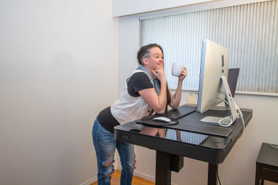 妇女在家工作在她的人体工程学的办公桌