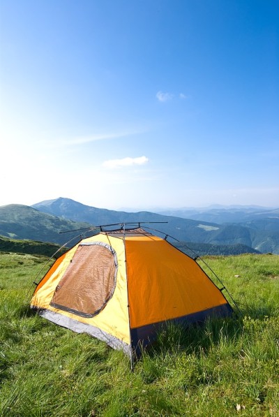 山间大草原上的橙色旅游帐篷