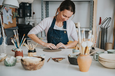 young artisan woman working with her hand a piece 