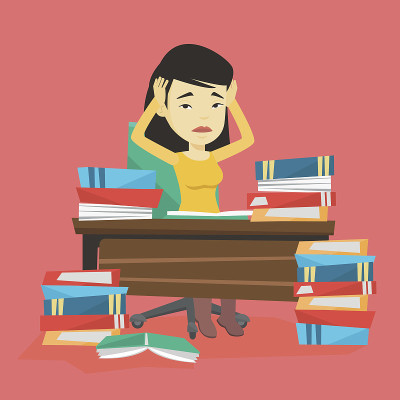 学生坐在桌子旁，手里拿着成堆的书