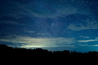 长曝光和高ISO拍摄的星星和银河在夜空与移动的云在晚上。