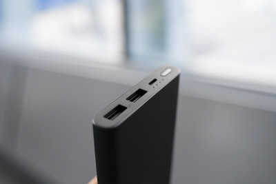 男人拿着电源和充电器。Powerbank。适用于智能手机等设备的节电装置。帮你给手机充电。