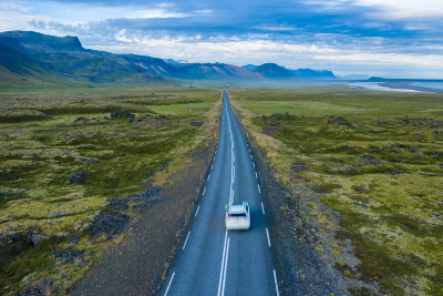 孤独的出租汽车行驶在风景秀丽的冰岛Snaefellsnes地区的偏远道路上